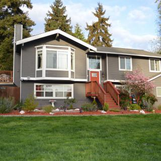A suburban house with a landscaped yard and surrounding trees.