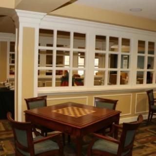 A cozy room with a chessboard on a wooden table surrounded by chairs.