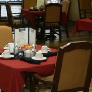 A dining table set with cups and menus in a restaurant.