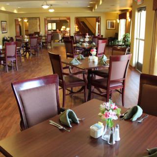 A cozy dining area with neatly arranged tables and chairs, featuring elegant decor.