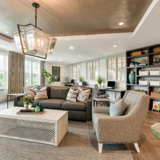 A modern living room featuring a large sofa, comfortable armchairs, a chic coffee table, and ample natural light from large windows.