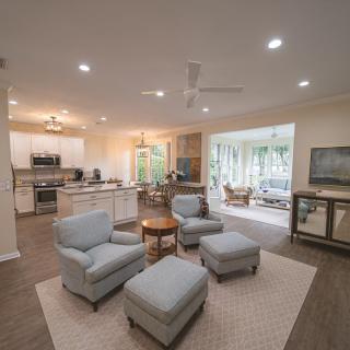 A spacious open-concept living room and kitchen area with modern furnishings and cozy seating.