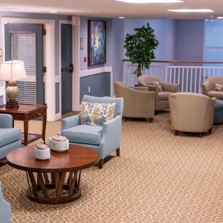 A cozy seating area with armchairs and a coffee table, featuring soft lighting and decorative elements.