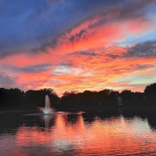 A serene sunset reflecting on the calm waters of a lake, highlighting the beauty of nature.