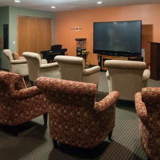 A cozy home theater setup with comfortable seating and a large television screen.