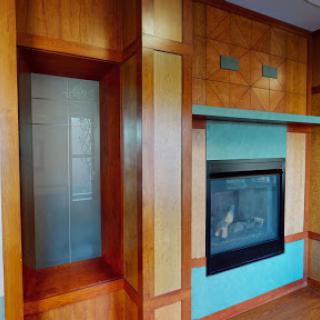 A beautifully designed interior featuring a modern fireplace with vibrant blue accents and elegant wood paneling.