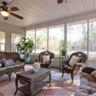 A cozy sunroom with wicker furniture and abundant natural light.