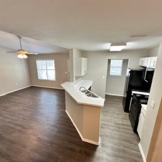 A spacious and modern open-concept apartment featuring a well-equipped kitchen and inviting living area.