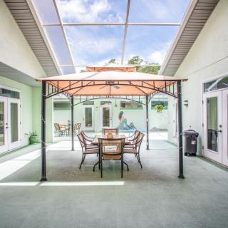 A modern courtyard with a gazebo and outdoor seating under a glass roof.