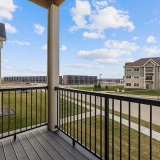A suburban balcony overlooking a residential neighborhood with clear skies.