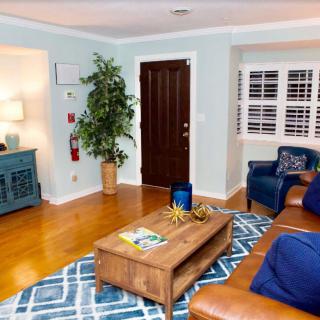 A cozy living room with a leather sofa, wooden coffee table, and indoor plants.