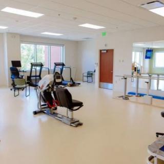 A spacious gym with exercise equipment and bright lighting.
