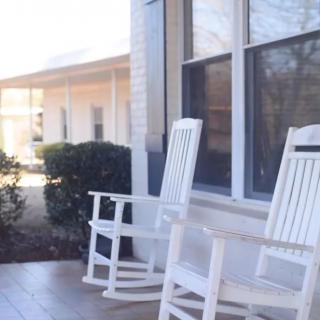 A cozy front porch with two white rocking chairs.