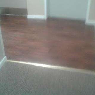 Transition between carpet and wooden flooring in an interior space.