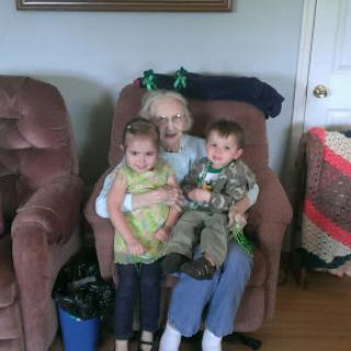 A heartwarming moment of family bonding, featuring two children sitting on the lap of an elderly relative.