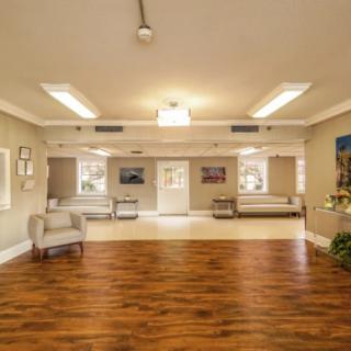 A spacious and elegantly decorated lobby with wooden flooring and comfortable seating.