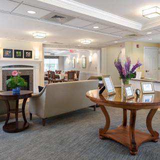 A well-decorated lobby with a sofa, flowers on tables, and framed pictures on the wall.