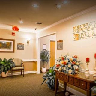 A well-decorated lobby area featuring floral arrangements, seating, and warm lighting.