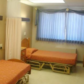A hospital room with two beds and curtains dividing the space.