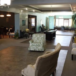 A spacious and modern lounge area with various seating options and a pool table.