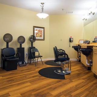A modern beauty salon with hairdryers, chairs, and a mirrored workstation.