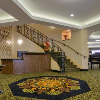 Hotel lobby with a stylish carpet and elegant staircase.