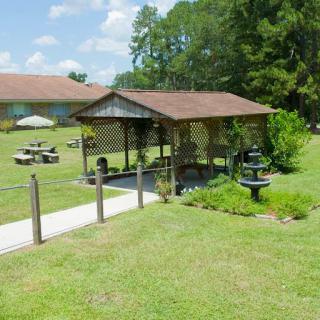 A peaceful outdoor pavilion set in a grassy area, perfect for picnics and gatherings.
