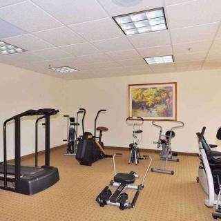 A small gym with various exercise equipment including a treadmill and stationary bikes.