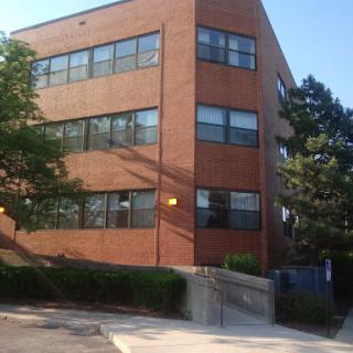 A brick building with large windows, likely a school or educational facility.
