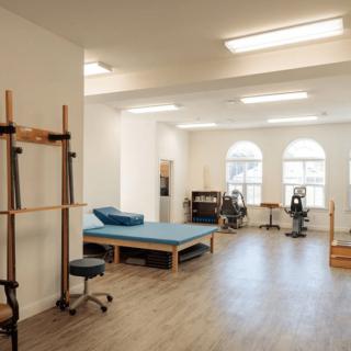 A bright and spacious art studio with several easels and a wooden floor.