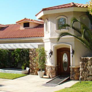 A luxurious residential house with a red-tiled roof and well-maintained garden.