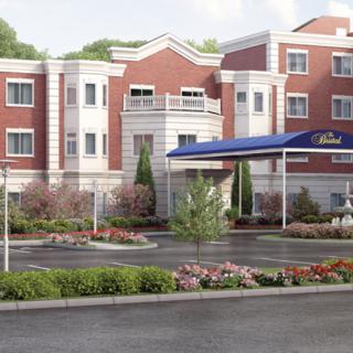 A modern hotel building with a well-maintained garden and entrance.