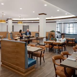A modern dining interior with wooden furniture and a well-lit atmosphere.