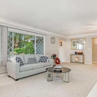 A bright and spacious living room with a sofa, coffee table, and large window.