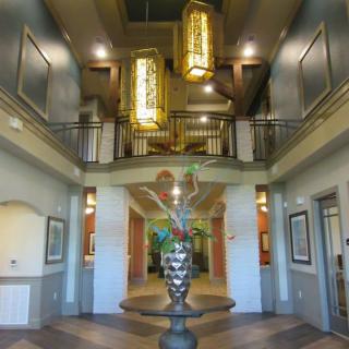 A spacious lobby with elegant chandeliers and a decorative fountain centerpiece.
