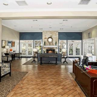 A spacious and elegantly decorated lobby area with a central fireplace and office desk.