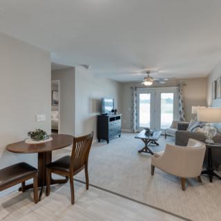 A modern apartment living space with a cozy dining area and comfortable seating.
