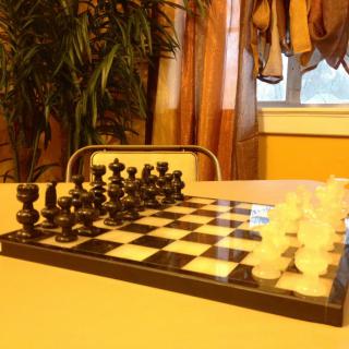 A chessboard set up for a game on a table indoors.