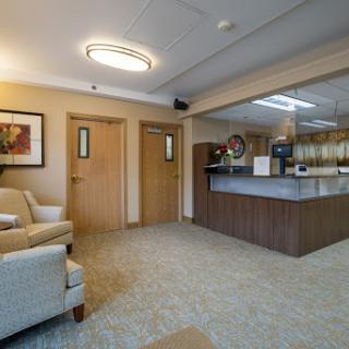 A cozy and inviting waiting room featuring comfortable seating and a reception desk.