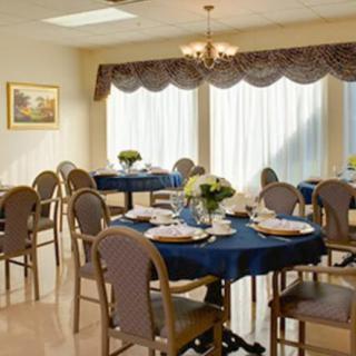 A neatly arranged dining room with elegantly set tables and comfortable chairs.