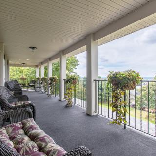 A spacious porch with comfortable seating and a view of the surrounding landscape.