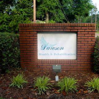 A welcoming sign for a location named 'Dawson' surrounded by lush greenery.