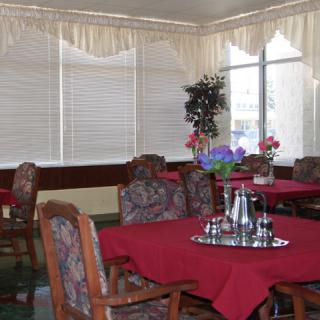 A cozy dining area with red tablecloths and decorative plants.