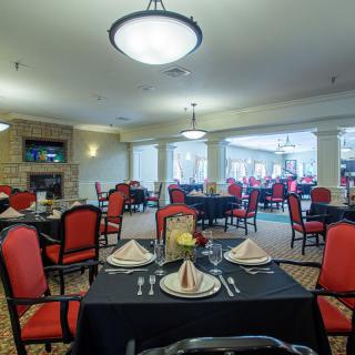 A spacious and elegantly decorated dining room with neatly arranged tables and chairs.
