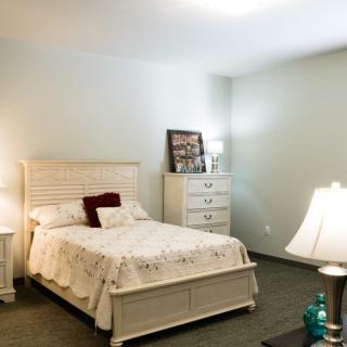 A cozy bedroom with a neatly made bed and elegant furnishings.
