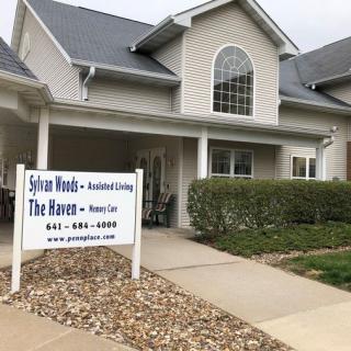 Front view of an assisted living facility with a sign out front.