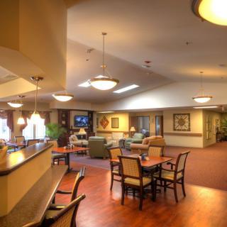 A cozy lobby area featuring comfortable seating, tables, and warm lighting.