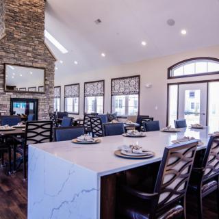 A modern kitchen and dining area featuring a stone fireplace and elegant decor.