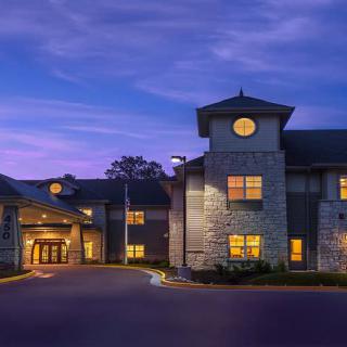 A beautifully lit building at dusk with a cloudy sky backdrop.