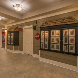 A tastefully decorated hallway featuring art displays and warm lighting.